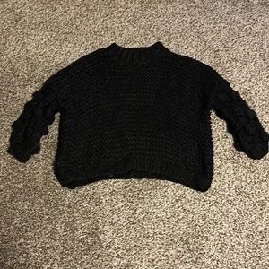 Beautiful black knitted sweater with balls on the sleeves. Never been worn.